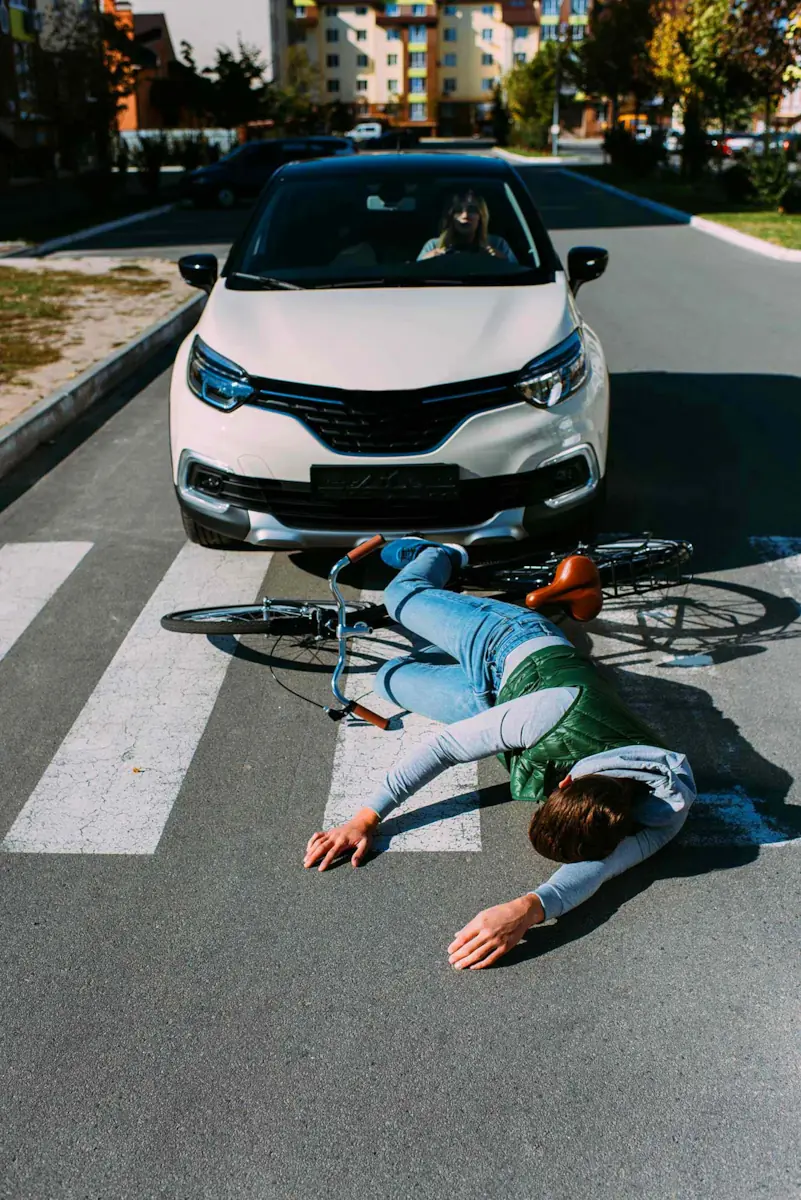 man laying down in street after getting hit by car.