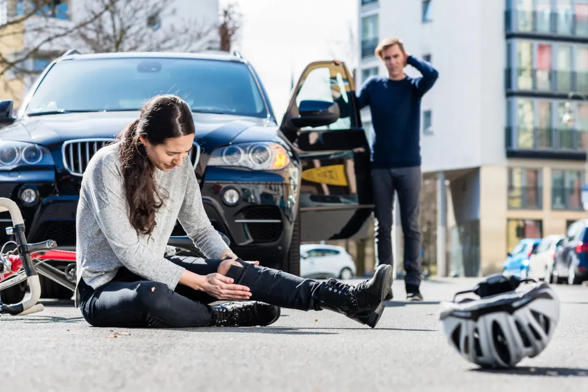 Woman holding leg in pain after bicycle accident